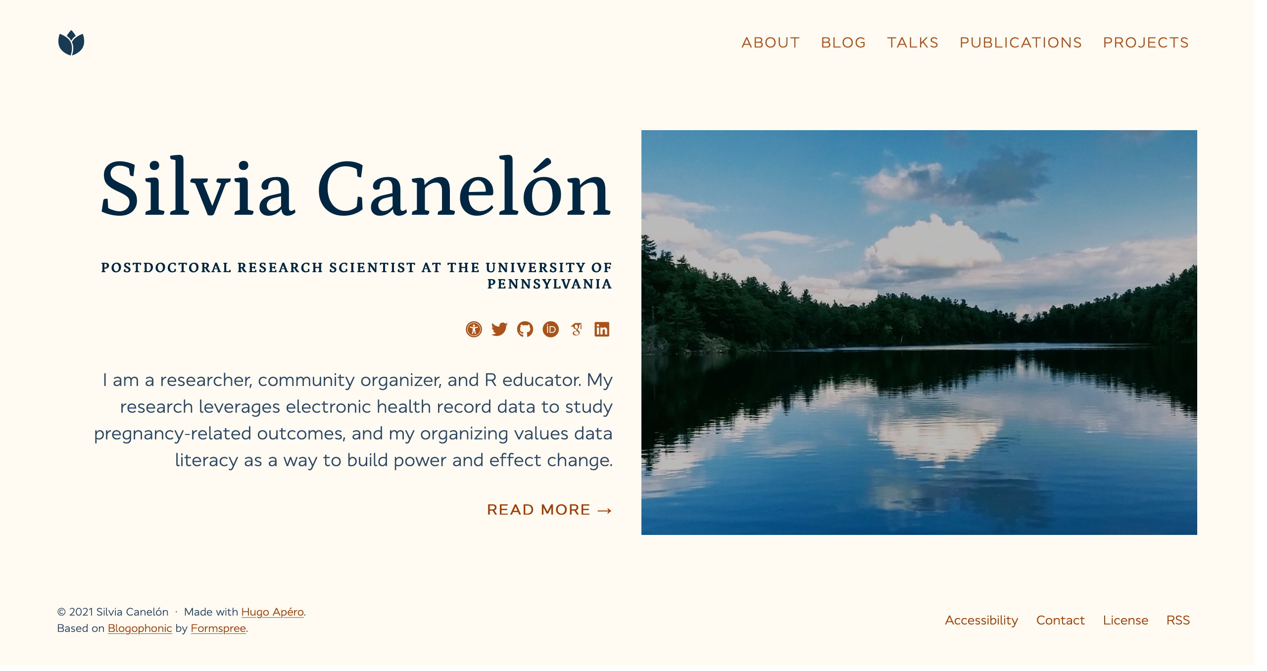 The homepage of my site which shows my name in large font on the left, my title, social media icons, a short blurb about me, and a link that says 'Read More' that can be clicked to enter the site. On the right side is a photo of one of my favorite lakes.